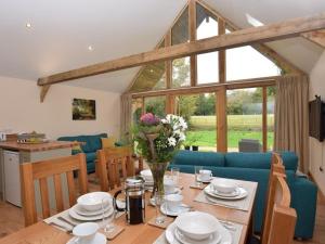 Durley的住宿－Nettlebed Farm Holiday Lets Barn3，客厅配有桌子和蓝色沙发
