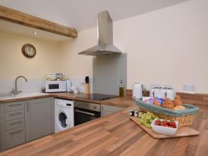 una cucina con piano di lavoro e cesto di frutta di Nettlebed Farm Holiday Lets Barn3 a Durley
