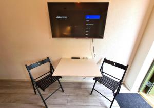 un tavolo con due sedie e una TV a parete di GEG Hotel a Landskrona