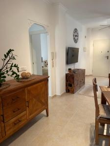 a living room with a wooden dresser and a television at Holiday Home Amari - Residencia Albatros in Los Alcázares