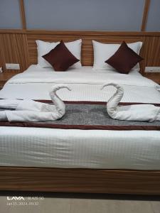 a bed with white sheets and towels on it at SURYAPRABHA HOLIDAY HOMES in Diveagar