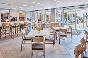 een restaurant met tafels, stoelen en ramen bij Hotel Trio Healdsburg in Healdsburg