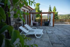 a pair of white chairs sitting on a patio at Casa da Ferreira_Vila Real in Vila Real