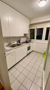 a kitchen with white cabinets and a sink at Gesamte Wohnung in Zurich in Kloten