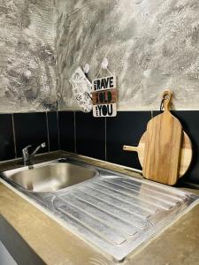 - un évier de cuisine avec une planche de coupe en bois à côté dans l'établissement Golden Maboneng, à Johannesbourg