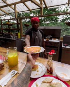 Ein Mann, der einen Teller Essen an einem Tisch hält. in der Unterkunft ZÂRIA in El Valle