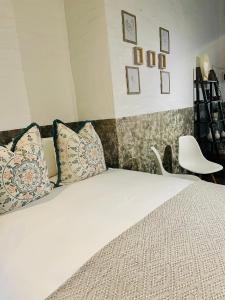 - une chambre avec un lit doté d'oreillers et d'une chaise dans l'établissement Golden Maboneng, à Johannesbourg