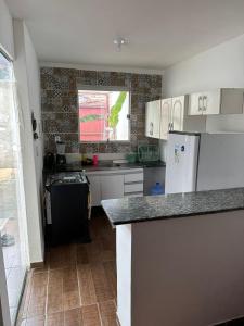 a kitchen with white cabinets and a counter top at dalton in Itacaré