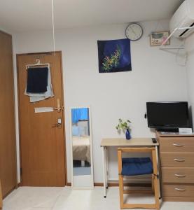 a room with a desk and a clock on the wall at 8-17 Nomura Motomachi - House / Vacation STAY 1894 in Hirakata