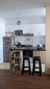 a kitchen with a counter and two bar stools at Apartamento en Piura - Perú in Piura