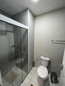 a bathroom with a toilet and a glass shower at Flat Aconchegante 1 in Sorocaba