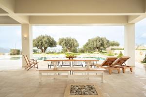 a patio with a table and chairs and a pool at Luxurious 6- Bed Private Villa in Heraklion Crete in Athánatoi