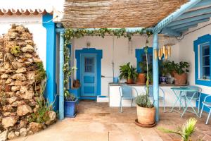 a blue and white house with a table and chairs at Algarve Quinta Estacao Alcantarilha Casa 1 e 2 in Alcantarilha