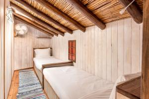 Duas camas num quarto com paredes de madeira em Algarve, Quinta Estacao Alcantarilha - Casa 1 em Alcantarilha