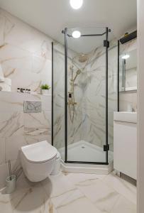 biała łazienka z prysznicem i toaletą w obiekcie Luminious apartment with balcony by Polo Apartments w Kownie