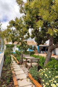 um parque com bancos e uma árvore e flores em Algarve, Quinta Estacao Alcantarilha - Casa 1 em Alcantarilha
