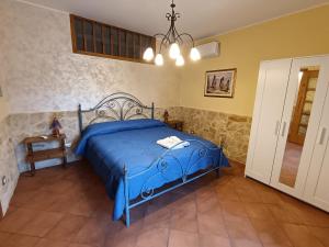 a bedroom with a blue bed in a room at Abbentu in Zafferana Etnea