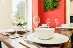 a wooden table with wine glasses and a bowl on it at Spacious 2-Bedroom Main Door Apartment With Private Parking in Glasgow +15 photos
