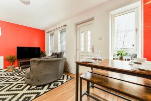 a living room with red walls and a table and a chair at Spacious 2-Bedroom Main Door Apartment With Private Parking in Glasgow