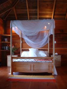 a bed in a room with a canopy at Castara Retreats in Castara
