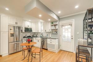 a kitchen with white cabinets and a wooden table at Pet-Friendly Alexandria Escape with Yard 8 Mi to DC in Alexandria