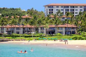 people on a beach with a hotel in the background at Wailea Beach Villas in Wailea
