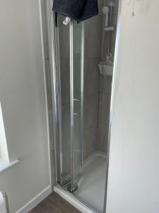 um chuveiro com uma porta de vidro na casa de banho em The Annexe. Enniskillen Town House. em Enniskillen