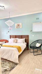 1 dormitorio con 1 cama grande y 1 silla en Chaya accommodation B&B and self catering, en Mzuzu