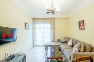 a living room with a couch and a tv at Résidence Palace - Racine in Casablanca