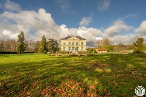 a large white house on a green field at Domaine du Chateau Vert in Hondainville