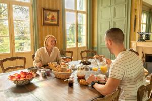 a man and woman sitting at a table eating food at Domaine du Chateau Vert in Hondainville +66 photos