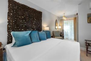 a bedroom with a large white bed with blue pillows at Shangri-La Springs in Bonita Springs