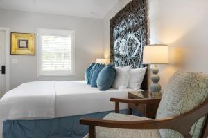 a bedroom with a large bed and a chair at Shangri-La Springs in Bonita Springs