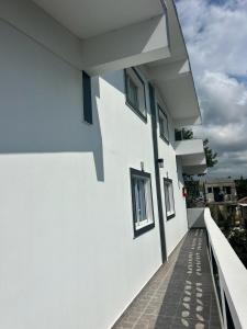 - un bâtiment blanc avec des fenêtres et une passerelle dans l'établissement HILLMON'S HOTEL BAR LOUNGE, à Sosúa