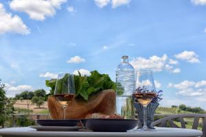 einen Tisch mit zwei Gläsern Wein und einer Flasche Wasser in der Unterkunft Resort Il Gallo Senone in Senigallia