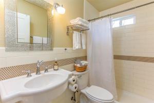 a bathroom with a sink and a toilet and a mirror at Cumberland Bungalow walking distance to downtown in Bend