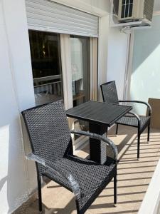 two chairs and a table on a balcony at White Apartment in Kavala
