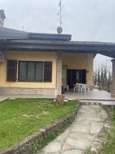 a yellow house with a patio and a table at Casa Gatti: villa con giardino con accesso indipendente in Rivanazzano