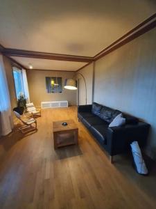 sala de estar con sofá negro y mesa en Lisebergs lyx Villa / Svenska Mässan / Ullevi, en Gotemburgo