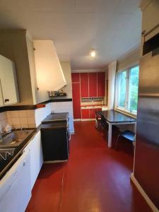 a kitchen with red cabinets and a red floor at Lisebergs lyx Villa / Svenska Mässan / Ullevi in Gothenburg