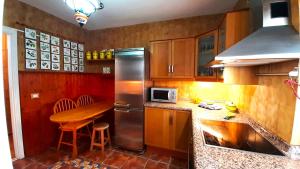 a kitchen with a table and a stainless steel refrigerator at Puerto Santiago Plaza in Puerto de Santiago