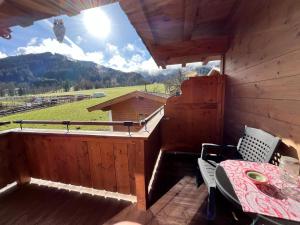 a balcony with a table and a view of a mountain at Trixlhof in Sankt Ulrich am Pillersee