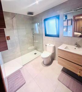 a bathroom with a toilet and a shower and a sink at Casa L'Escala 31 in L'Escala