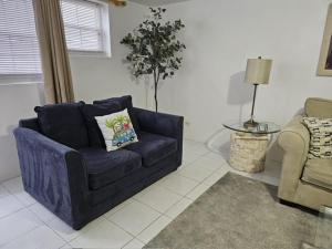 a living room with a blue couch and a chair at Calypso Steps Away From Home in Hinson Hall