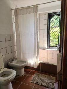 een badkamer met een toilet, een wastafel en een douche bij Casa BAUM in Yerba Buena