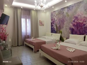 a room with two beds and a painting of flowers at Maison De luxe in Pompei