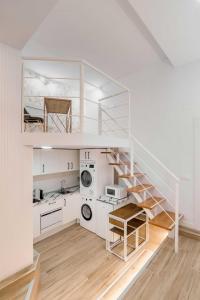 a white kitchen with a spiral staircase in a house at Apartamento lujoso cercano al centro de Madrid in Madrid