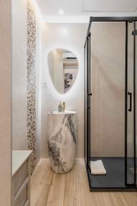y baño con lavabo de mármol y ducha. en Apartamento lujoso cercano al centro de Madrid en Madrid