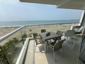 a balcony with a table and chairs and the beach at 2 Dormitorios Playa Morros y Vista Mar in Cartagena de Indias