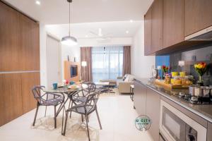 a kitchen and living room with a table and chairs at Grand Medini Suites by JBcity Home in Nusajaya